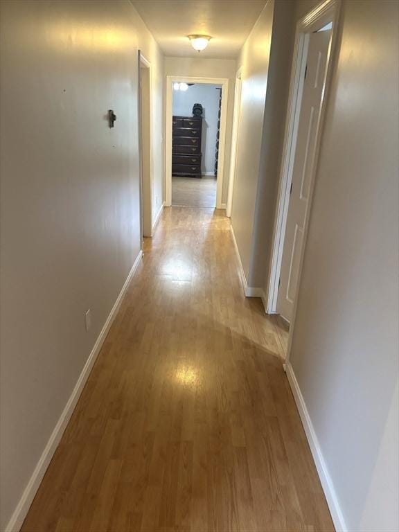 hallway with light wood-style floors and baseboards