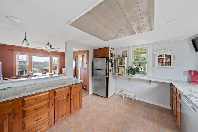20 Harlem Rd, Weymouth, MA 02191 - kitchen with stainless steel appliances, baseboards, brown cabinets, ceiling fan, and light stone counters