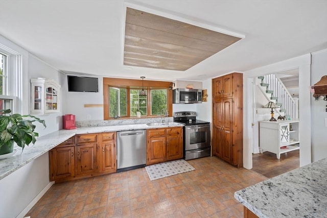 20 Harlem Rd, Weymouth, MA 02191 - kitchen featuring stainless steel appliances, a sink, brown cabinets, light stone counters, and pendant lighting