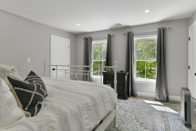 bedroom featuring visible vents, multiple windows, baseboards, and recessed lighting