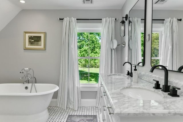 bathroom featuring a soaking tub, a sink, baseboards, and double vanity