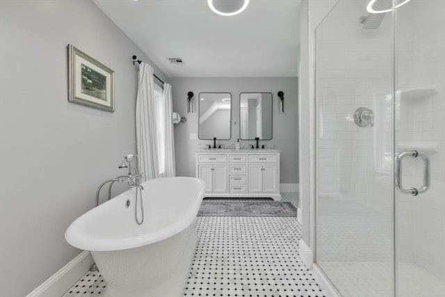 bathroom featuring a freestanding tub, a sink, a shower stall, and baseboards