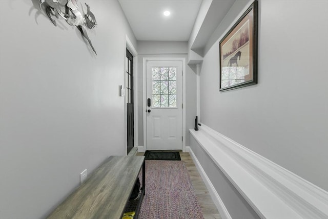 doorway featuring wood finished floors and baseboards