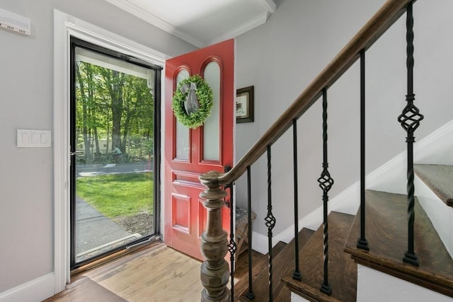 entrance foyer with crown molding, stairs, baseboards, and wood finished floors