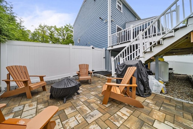 54 Forest St, Wilmington, MA 01887 - fenced backyard featuring a fire pit, stairs, a patio area, and a wooden deck