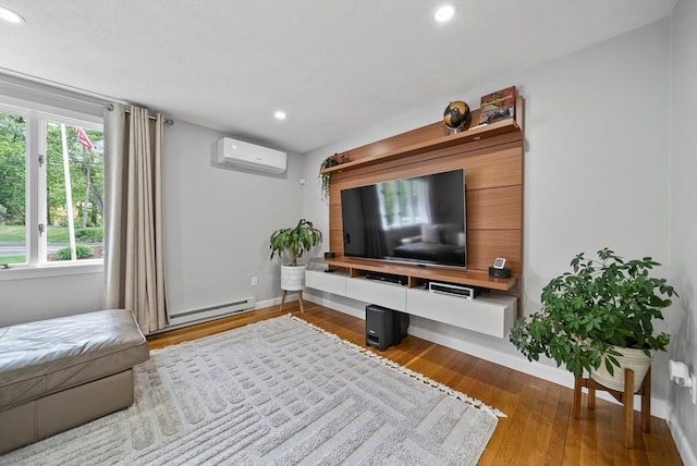 54 Forest St, Wilmington, MA 01887 - living room with a wall mounted AC, baseboard heating, recessed lighting, baseboards, and wood finished floors
