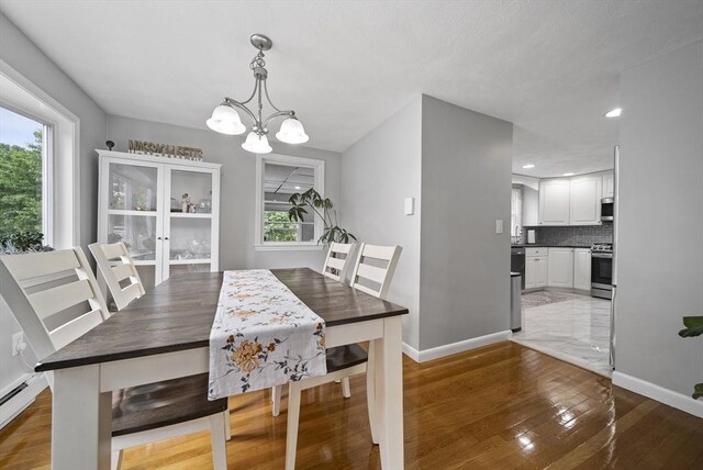 54 Forest St, Wilmington, MA 01887 - dining space with a chandelier, baseboards, light wood-style flooring, baseboard heating, and recessed lighting