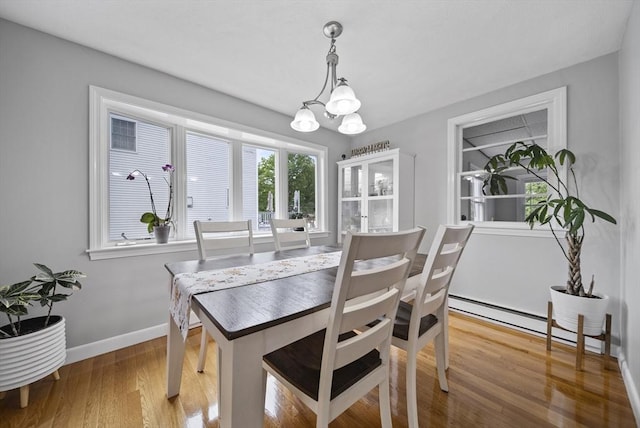 54 Forest St, Wilmington, MA 01887 - dining space with a chandelier, a baseboard radiator, baseboards, and wood finished floors