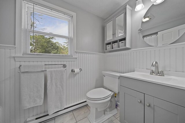 54 Forest St, Wilmington, MA 01887 - bathroom with a wainscoted wall, tile patterned floors, vanity, toilet, and baseboard heating