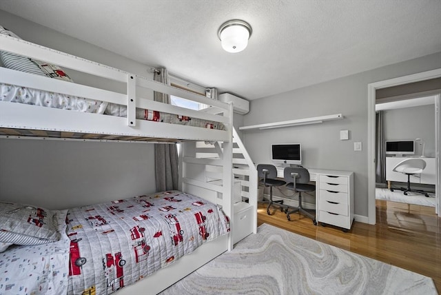 54 Forest St, Wilmington, MA 01887 - bedroom with wood finished floors, a desk, and a wall mounted air conditioner