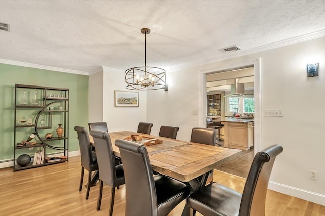 10 Ballard Ter, Lexington, MA 02420 - dining room with light wood finished floors, crown molding, a chandelier, baseboards, and a textured ceiling