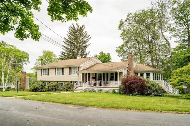 10 Ballard Ter, Lexington, MA 02420 - split level home featuring covered porch, a front yard, a chimney, and stairway