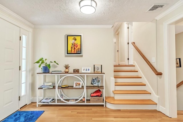 10 Ballard Ter, Lexington, MA 02420 - foyer featuring wood finished floors, stairway, a textured ceiling, ornamental molding, and baseboards