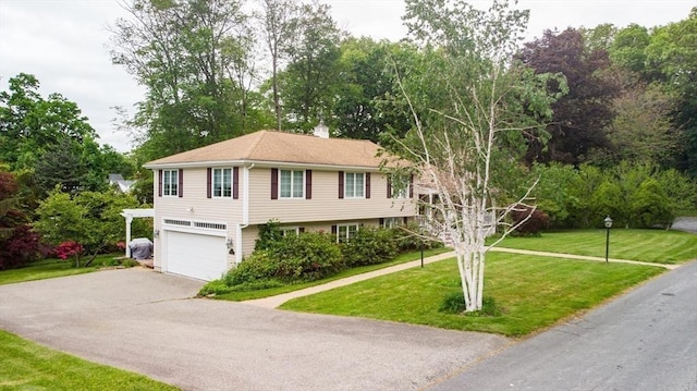 10 Ballard Ter, Lexington, MA 02420 - view of front of property featuring asphalt driveway, a garage, a front yard, a chimney, and view of wooded area