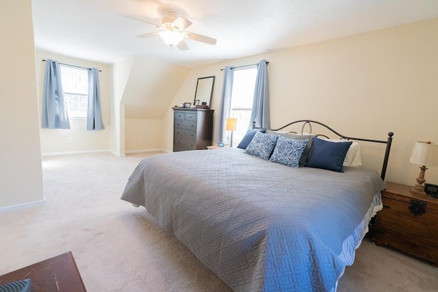 bedroom with multiple windows, a ceiling fan, baseboards, and light carpet