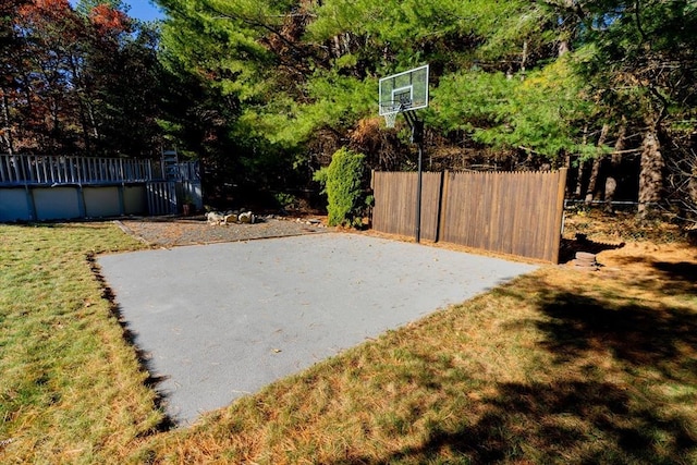 exterior space featuring an outdoor pool, a yard, basketball court, and fence