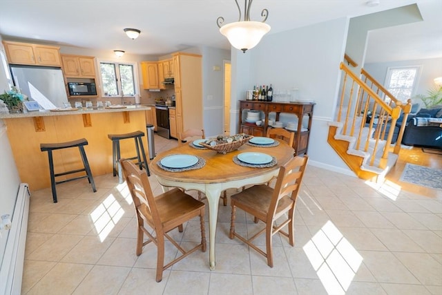 dining room with light tile patterned floors, stairs, a baseboard heating unit, and baseboards