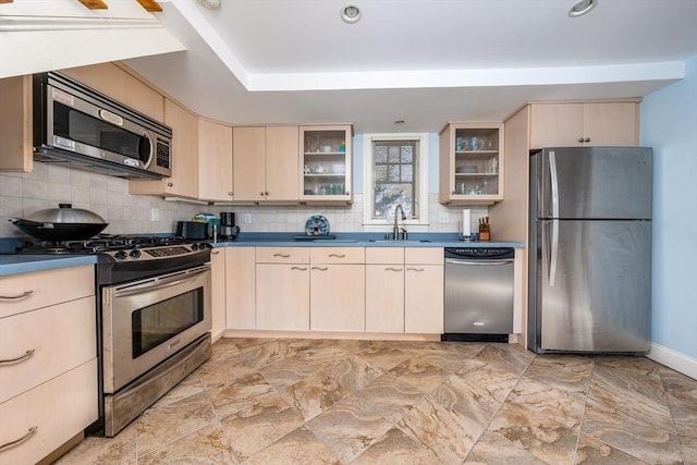 kitchen featuring tasteful backsplash, sink, stainless steel appliances, and a raised ceiling