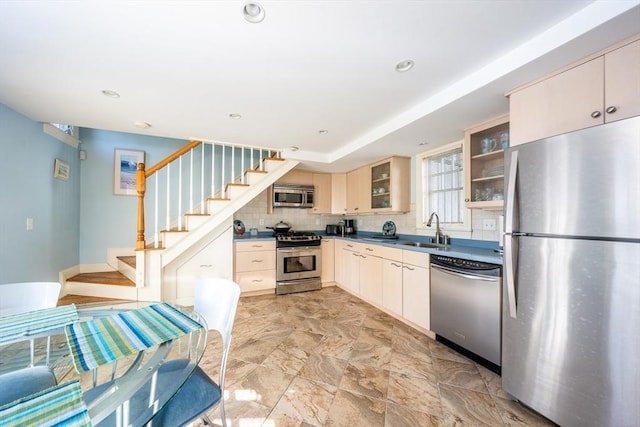 kitchen featuring cream cabinets, stainless steel appliances, sink, and decorative backsplash