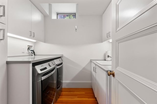 20 Birch Hill Rd, Newton, MA 02465 - laundry area with cabinet space, washer and clothes dryer, and light wood-style flooring