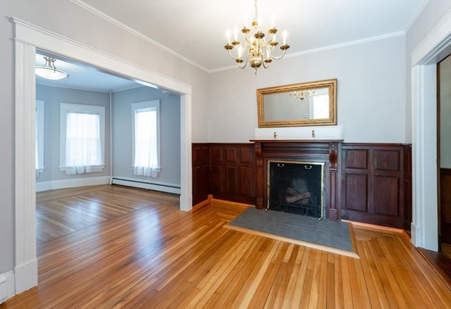 23 Shawmut Ave, Lowell, MA 01851 - unfurnished living room featuring a baseboard heating unit, wood finished floors, a chandelier, a fireplace, and ornamental molding