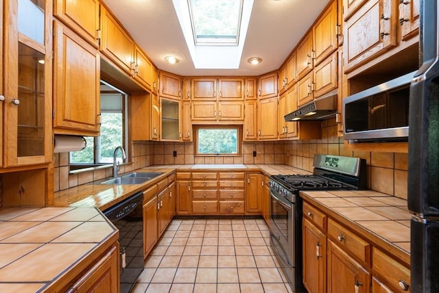 23 Shawmut Ave, Lowell, MA 01851 - kitchen featuring tile counters, stainless steel appliances, a sink, and under cabinet range hood