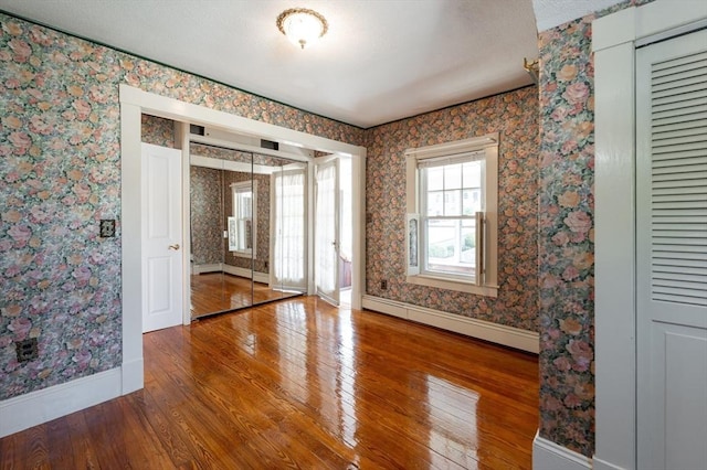 23 Shawmut Ave, Lowell, MA 01851 - unfurnished room with baseboards, hardwood / wood-style floors, a baseboard radiator, and wallpapered walls
