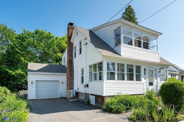 23 Shawmut Ave, Lowell, MA 01851 - view of front of property with driveway, a garage, a chimney, and roof with shingles