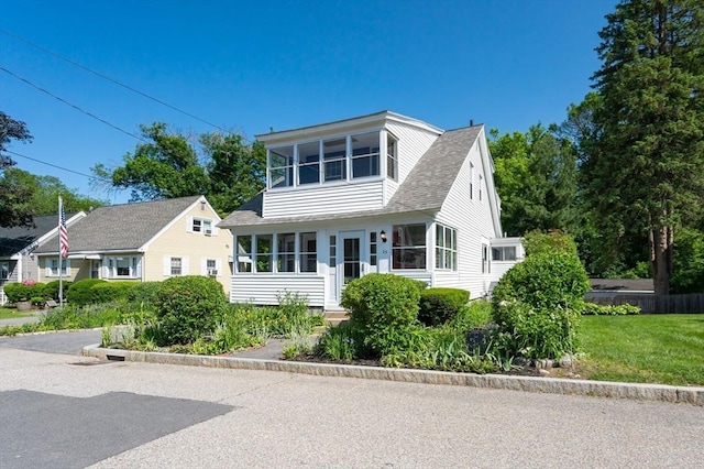 23 Shawmut Ave, Lowell, MA 01851 - view of front of home with roof with shingles, a sunroom, and a front yard