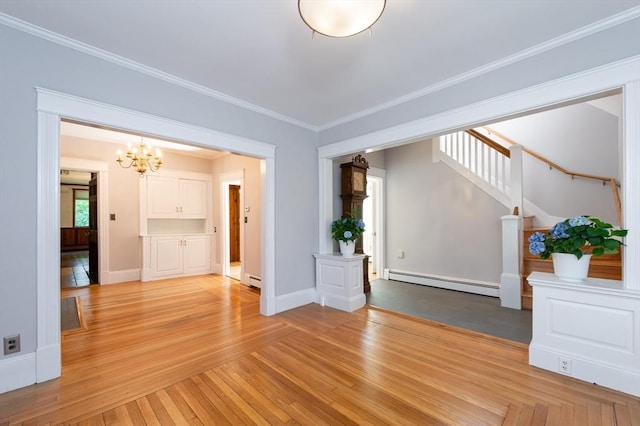 23 Shawmut Ave, Lowell, MA 01851 - spare room with a baseboard heating unit, stairs, a chandelier, ornamental molding, and light wood finished floors