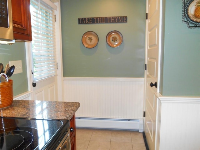 951 Dana Rd, Barre, MA 01005 - kitchen with a baseboard heating unit, a wainscoted wall, dark countertops, and light tile patterned floors