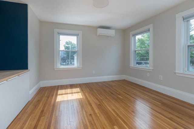 27 Round Hill St, Boston, MA 02130 - spare room with an AC wall unit, light wood-style floors, and plenty of natural light