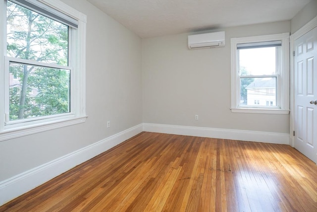 27 Round Hill St, Boston, MA 02130 - unfurnished bedroom with a wall unit AC, light wood-type flooring, and multiple windows