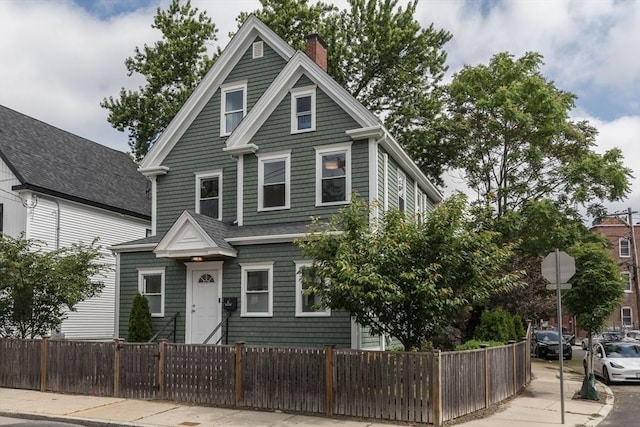 27 Round Hill St, Boston, MA 02130 - view of front of house with a fenced front yard and a chimney