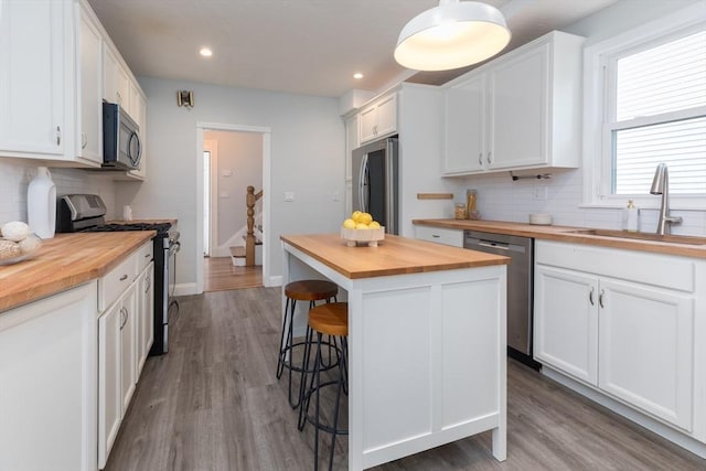 27 Round Hill St, Boston, MA 02130 - kitchen with butcher block counters, stainless steel appliances, backsplash, and recessed lighting