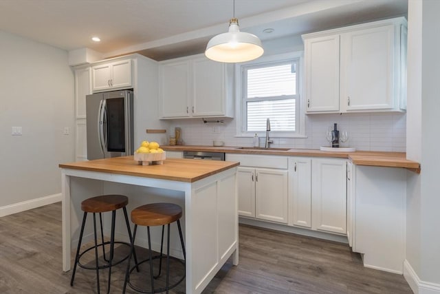 27 Round Hill St, Boston, MA 02130 - kitchen featuring wood counters, stainless steel appliances, white cabinetry, and recessed lighting