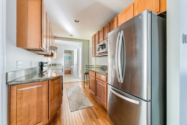 kitchen with stainless steel appliances and light hardwood / wood-style floors