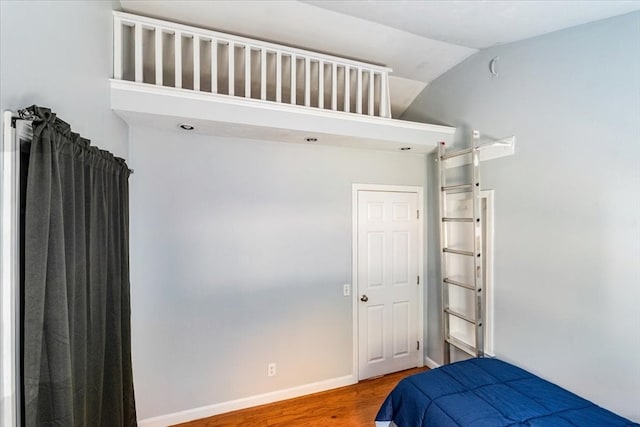 bedroom featuring lofted ceiling and hardwood / wood-style floors