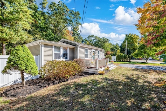 view of side of property with a wooden deck and a lawn