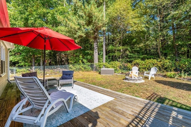 wooden deck with a lawn and a fire pit