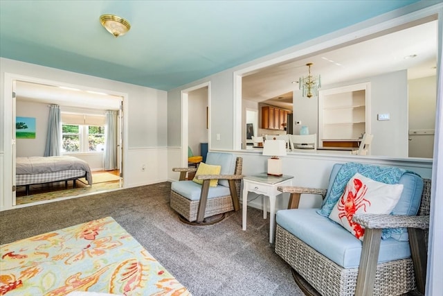 sitting room featuring a chandelier and carpet flooring