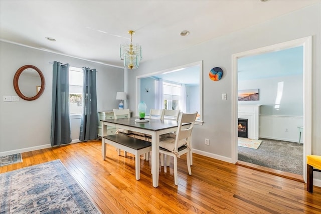 dining room featuring light hardwood / wood-style floors, a healthy amount of sunlight, and a chandelier