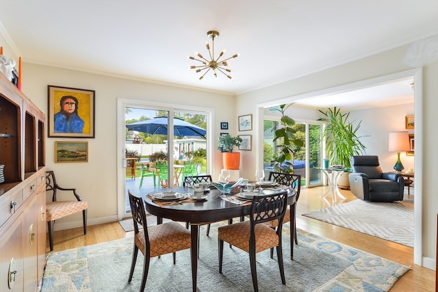 dining room featuring crown molding, light hardwood / wood-style floors, and a chandelier