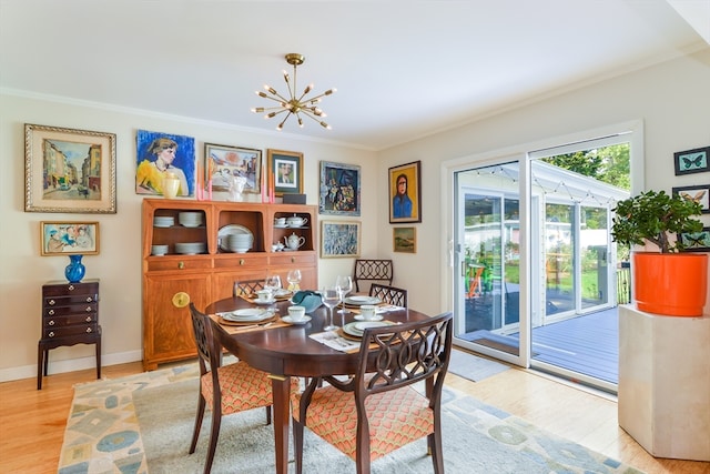 dining area featuring light hardwood / wood-style floors, ornamental molding, and a chandelier