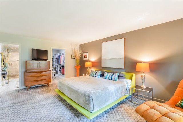 bedroom featuring a closet, a walk in closet, and carpet floors