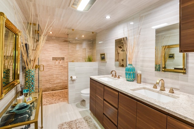 bathroom featuring tile walls, vanity, an enclosed shower, and toilet