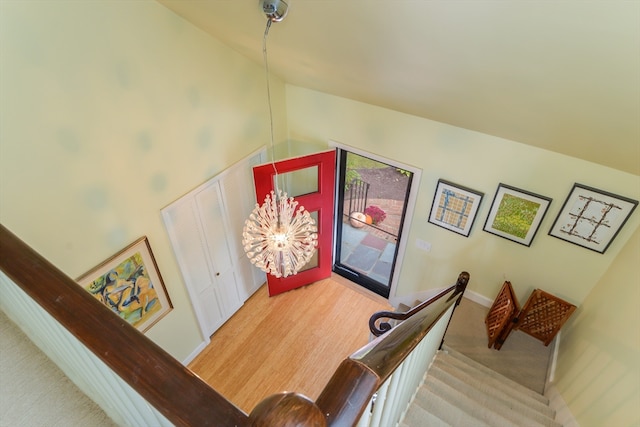 entryway with light hardwood / wood-style flooring, high vaulted ceiling, and an inviting chandelier