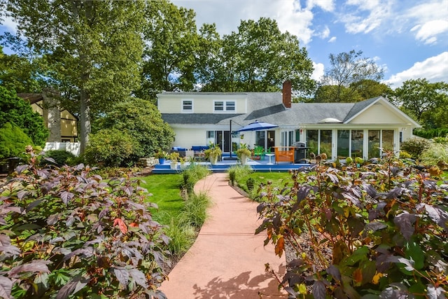 rear view of property featuring a sunroom