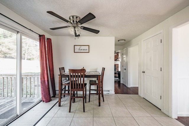 dining space featuring light wood-type flooring, a textured ceiling, and ceiling fan