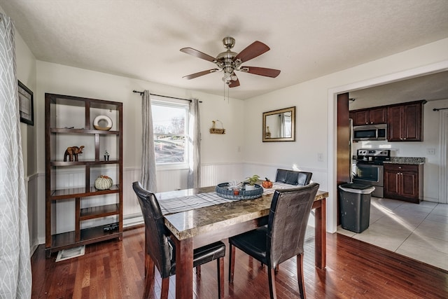 dining area featuring hardwood / wood-style flooring, ceiling fan, and a textured ceiling